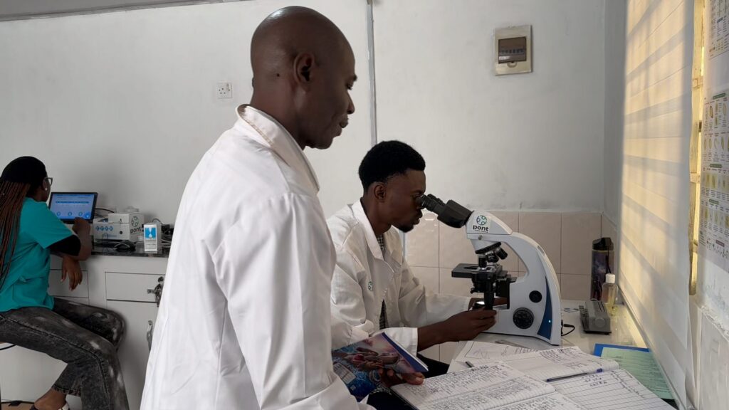 Laboratory staff at a Pont clinic examine samples under a microscope